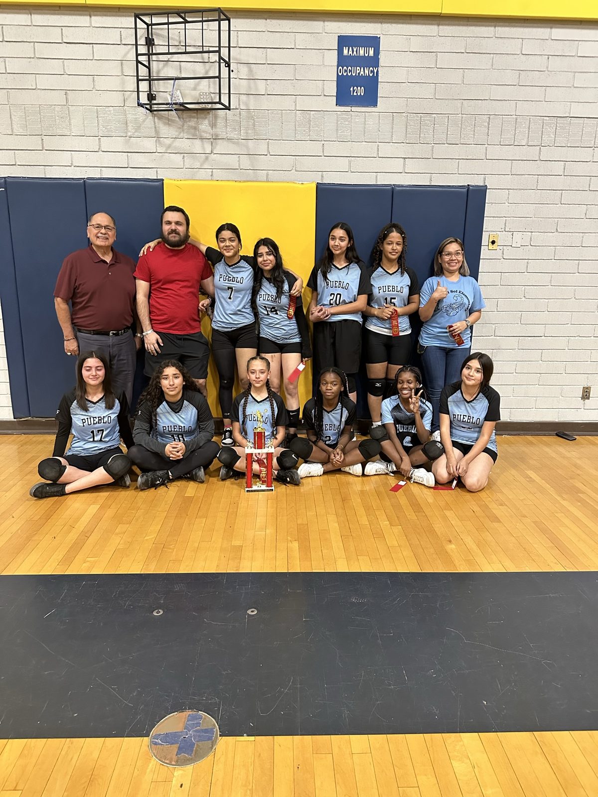 Harry Garewal with a junior-high girls volleyball team and trophy